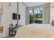 Bedroom featuring large windows with tree views, a mounted TV, and elegant decor at 1820 Peachtree St # 311, Atlanta, GA 30309