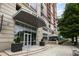 Upscale apartment building exterior featuring a covered entrance, landscaping, and sidewalk access at 1820 Peachtree St # 311, Atlanta, GA 30309