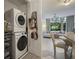 Efficient laundry area with stacked washer and dryer, plus view of living area with natural light at 1820 Peachtree St # 311, Atlanta, GA 30309