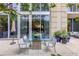Charming patio featuring a glass table, seating, and views of the surrounding greenery and building at 1820 Peachtree St # 311, Atlanta, GA 30309