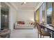 Cozy sitting room with a sofa, a desk, and a view of greenery through the sliding glass door at 1820 Peachtree St # 311, Atlanta, GA 30309