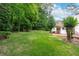 A backyard view with grass, trees, the home, and a brick patio at 2655 Hayden Dr, East Point, GA 30344