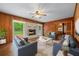 Cozy living room featuring wood paneling, a brick fireplace, and comfortable seating area at 2655 Hayden Dr, East Point, GA 30344