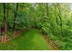 Lush green backyard surrounded by a split rail fence and mature trees at 3370 Ashton Dr, Suwanee, GA 30024