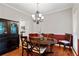 Elegant dining room with hardwood floors, wainscoting, a chandelier and a view of an adjacent kitchen at 3370 Ashton Dr, Suwanee, GA 30024