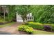 Inviting two-story home with a lush green lawn and a charming front porch, complemented by mature trees at 3370 Ashton Dr, Suwanee, GA 30024