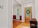 Warm foyer featuring hardwood floors, and an adjacent dining area with a red accent wall and wainscotting at 3370 Ashton Dr, Suwanee, GA 30024