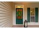 Welcoming front door with a glass pane, decorative wreath, classic lantern, and complementary green shutters at 3370 Ashton Dr, Suwanee, GA 30024