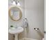 Charming half bath featuring a round mirror, pedestal sink, and classic fixtures at 3370 Ashton Dr, Suwanee, GA 30024