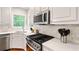 Kitchen with white quartz counters, stainless appliances, and stylish backsplash at 3370 Ashton Dr, Suwanee, GA 30024