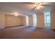Expansive bonus room featuring carpet, ceiling fans, and dormer windows at 1210 Lancelot Ct, Loganville, GA 30052