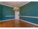 Elegant dining room features hardwood floors, a chandelier, stylish wall trim and a doorway to another room at 1210 Lancelot Ct, Loganville, GA 30052