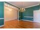Elegant dining room features hardwood floors, a chandelier, stylish wall trim and an open doorway to another room at 1210 Lancelot Ct, Loganville, GA 30052