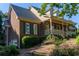 Brick home featuring a side entry garage, well-maintained landscaping, and a covered front porch at 1210 Lancelot Ct, Loganville, GA 30052