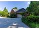 Brick home exterior featuring a two-car garage, driveway, and lush landscaping at 1210 Lancelot Ct, Loganville, GA 30052