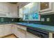 Kitchen with white cabinetry, stainless sink, dishwasher and stainless appliances at 1210 Lancelot Ct, Loganville, GA 30052