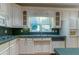 White kitchen cabinetry, stainless sink, dishwasher, and light countertops at 1210 Lancelot Ct, Loganville, GA 30052