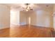 Spacious living room featuring hardwood floors, a ceiling fan, and ample natural light, ideal for relaxing at 1210 Lancelot Ct, Loganville, GA 30052