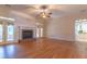 Spacious living room featuring hardwood floors, a fireplace, doors to sunroom, and a kitchen view at 1210 Lancelot Ct, Loganville, GA 30052