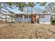 Charming one-story home with a gray exterior, orange front door, and a covered parking area on a sunny day at 2608 Barge Sw Rd, Atlanta, GA 30331