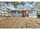 Cozy home features a well-maintained yard, orange front door, and convenient covered parking at 2608 Barge Sw Rd, Atlanta, GA 30331