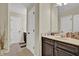 Bathroom featuring dark cabinets, a large mirror and natural light that shines through the window at 412 Live Oak Pass, Loganville, GA 30052