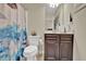 Cozy bathroom features a blue shower curtain and a dark wood vanity with a mirror at 412 Live Oak Pass, Loganville, GA 30052