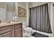 Bathroom with dark wood vanity, a shower with grey shower curtain, and light tile flooring at 412 Live Oak Pass, Loganville, GA 30052