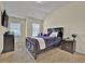Charming bedroom with a dark wood bed frame, two windows, and a matching nightstand and dresser at 412 Live Oak Pass, Loganville, GA 30052