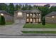 Charming two-story brick home featuring a double-door garage and welcoming front porch and upstairs balcony at dusk at 412 Live Oak Pass, Loganville, GA 30052