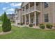 Inviting front porch and balcony adorned with decorative chairs and lush landscaping at 412 Live Oak Pass, Loganville, GA 30052