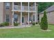 Inviting front porch and balcony adorned with decorative chairs and lush landscaping at 412 Live Oak Pass, Loganville, GA 30052
