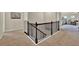Carpeted hallway with black metal railing, white trim, and a bedroom entrance at 412 Live Oak Pass, Loganville, GA 30052