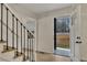 Bright foyer featuring hardwood floors, staircase with black railing, and modern front door at 2328 Carnes Rd, Jonesboro, GA 30236