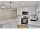 Modern kitchen features white cabinets, stainless appliances, and marble countertops at 2328 Carnes Rd, Jonesboro, GA 30236