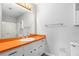 Bright bathroom featuring an orange countertop, white cabinets, and a shower with white tiling at 1023 Chartley Sw Dr, Lilburn, GA 30047