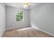 Bedroom featuring neutral walls, carpet, closet, and a window bringing in lots of natural light at 1023 Chartley Sw Dr, Lilburn, GA 30047