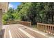 A spacious wooden deck is framed by lush greenery, providing a serene outdoor space for relaxation and entertainment at 1023 Chartley Sw Dr, Lilburn, GA 30047