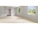 Spacious living room with built-in bookcases, carpet, and a view of the outdoors through large windows at 1023 Chartley Sw Dr, Lilburn, GA 30047