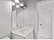 Small bathroom features a white vanity and sink with modern light fixture at 1101 Cooks Farm Way, Woodstock, GA 30189