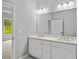 Bright bathroom features double vanity, gold hardware, and large mirror at 1101 Cooks Farm Way, Woodstock, GA 30189
