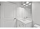 Bathroom with a white single sink vanity, sleek faucet, modern lighting and a door at 1101 Cooks Farm Way, Woodstock, GA 30189