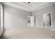 Spacious carpeted bedroom with tray ceiling, and doorway leading to another room at 1101 Cooks Farm Way, Woodstock, GA 30189