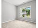 Bright, carpeted bedroom featuring a large window with views of the outdoors at 1101 Cooks Farm Way, Woodstock, GA 30189