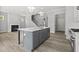 Open concept kitchen with gray island, stainless appliances, and hardwood floors at 1101 Cooks Farm Way, Woodstock, GA 30189