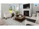 Cozy living room boasts a fireplace, large windows with backyard views, and stylish furniture at 1101 Cooks Farm Way, Woodstock, GA 30189