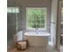 Stylish bathroom with a freestanding tub, glass-enclosed shower, and a large window for natural light at 1200 Larson Sw Ln, Marietta, GA 30064