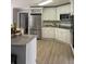 Modern kitchen features stainless appliances, granite counters, white cabinets, and hardwood floors at 1200 Larson Sw Ln, Marietta, GA 30064
