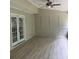Covered patio featuring neutral-toned walls, wood-look flooring, and double French doors to the interior at 1200 Larson Sw Ln, Marietta, GA 30064