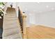 Bright foyer featuring hardwood floors, modern railing, and staircase with carpeted steps at 136 Peachtree Memorial Nw Dr # Nj2, Atlanta, GA 30309